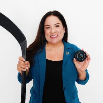 A lady holding a hockey stick and puck