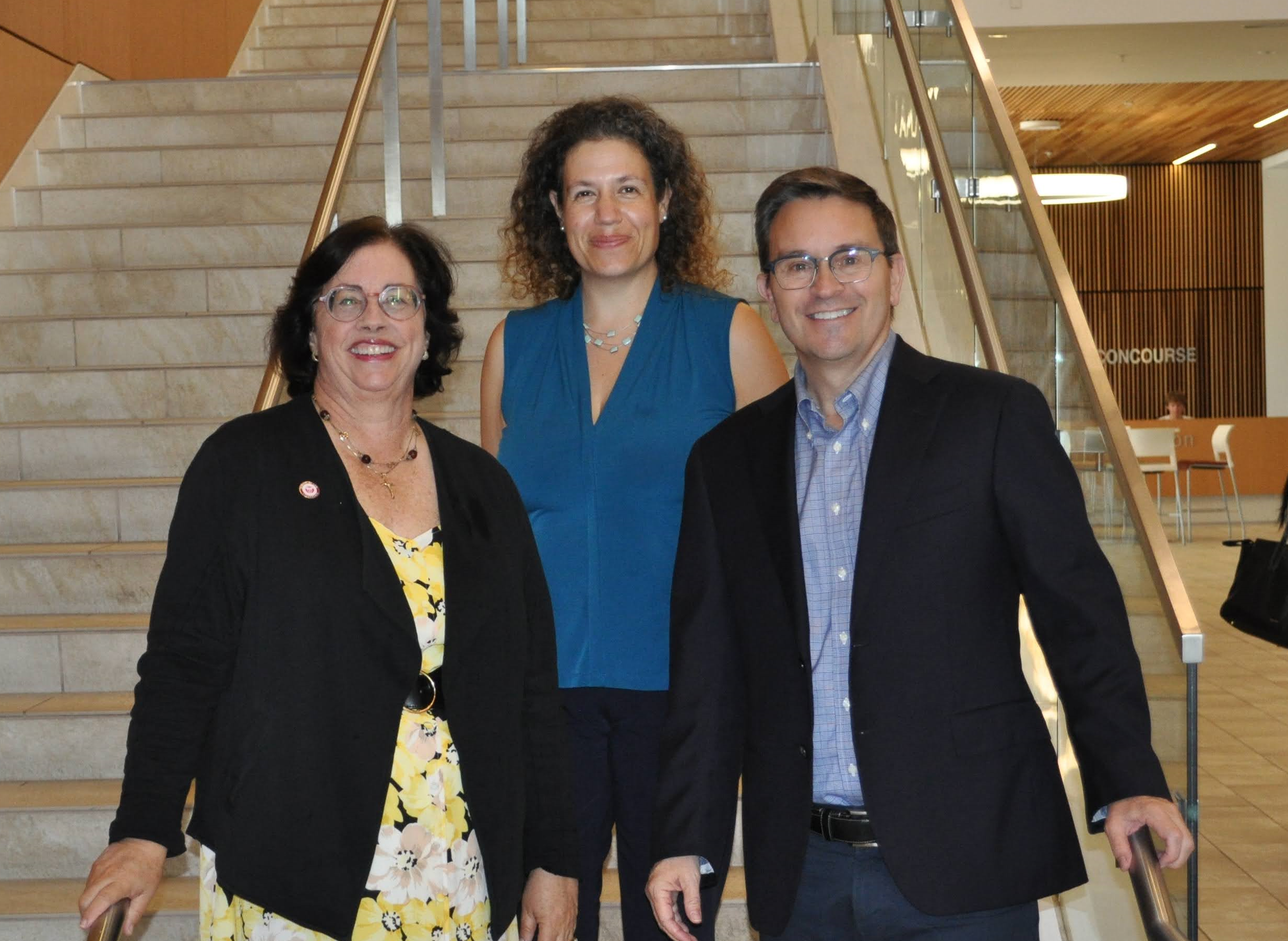 Three faculty members standing on stairs