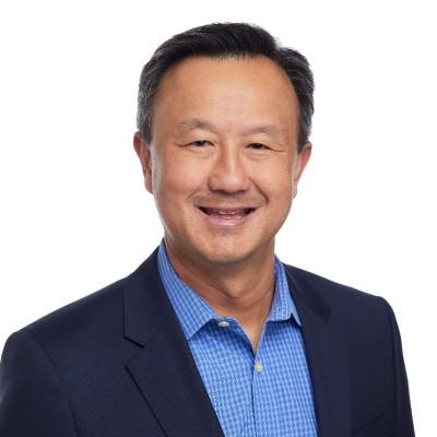 headshot of prof john kuo an asian man with black hair wearing cornflower blue button down shirt and navy blue blazer
