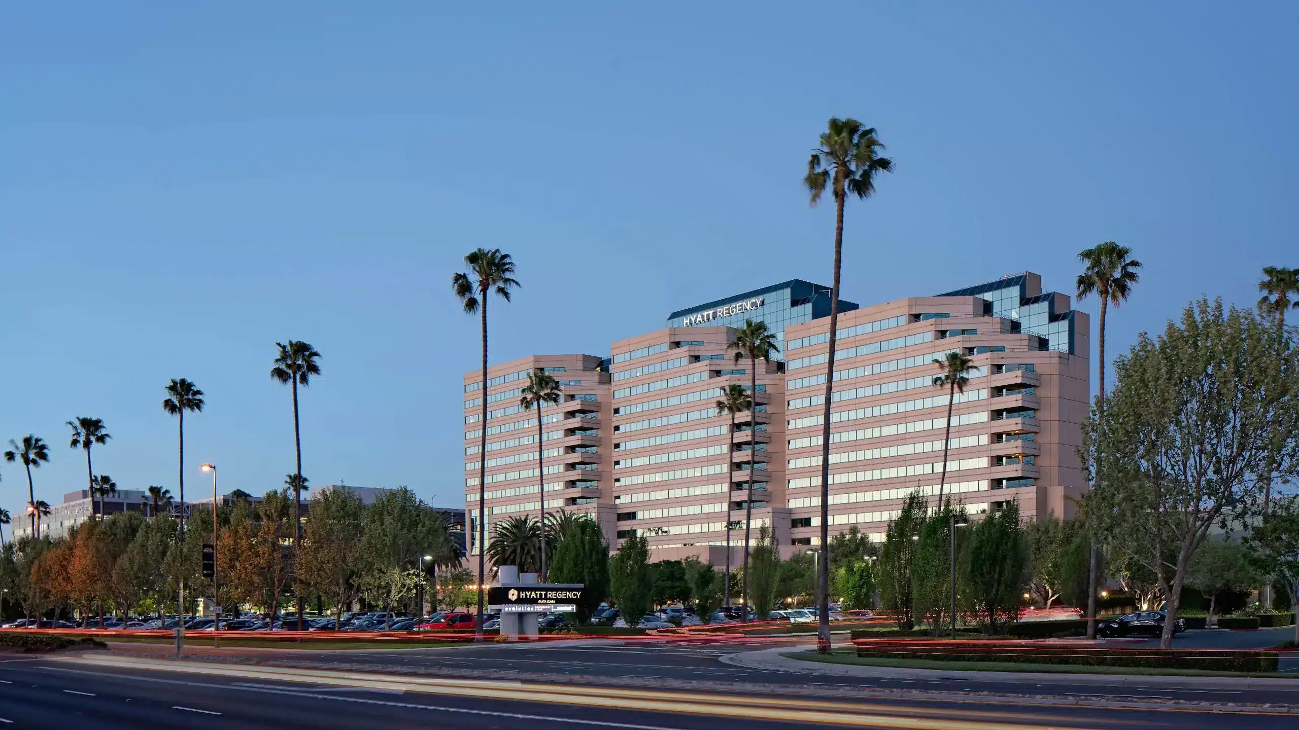 Santa Clara Hotel exterior view with 3 palm trees on a sunny day 