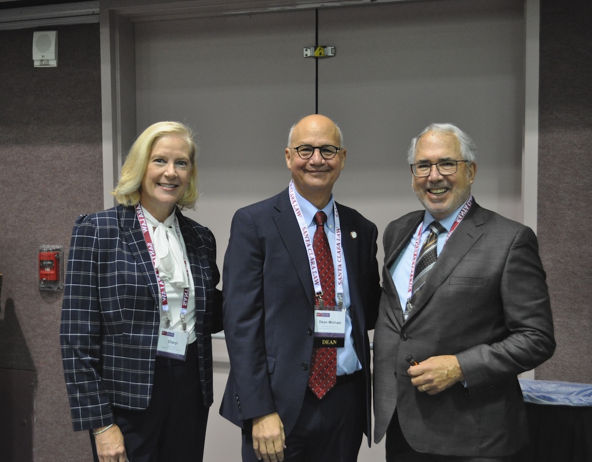 staff and Dean Kaufman in front of a booth at Kasner Symposium
