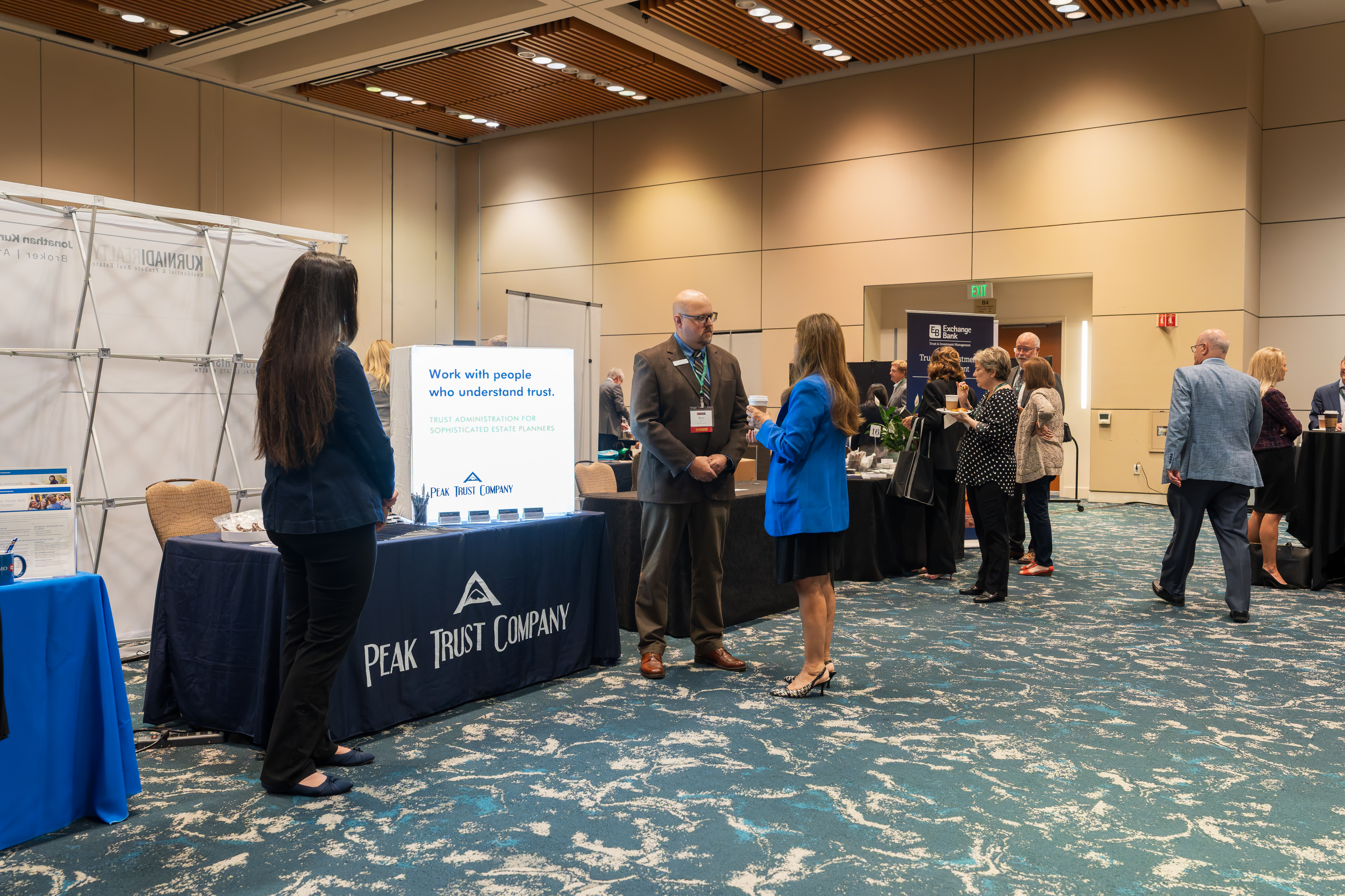 People standing around a booth getting more information about them.