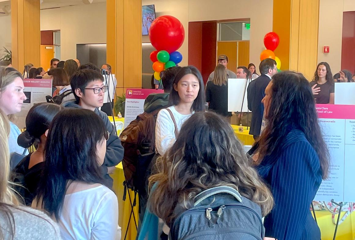 Handful of students gather around professor who is speaking