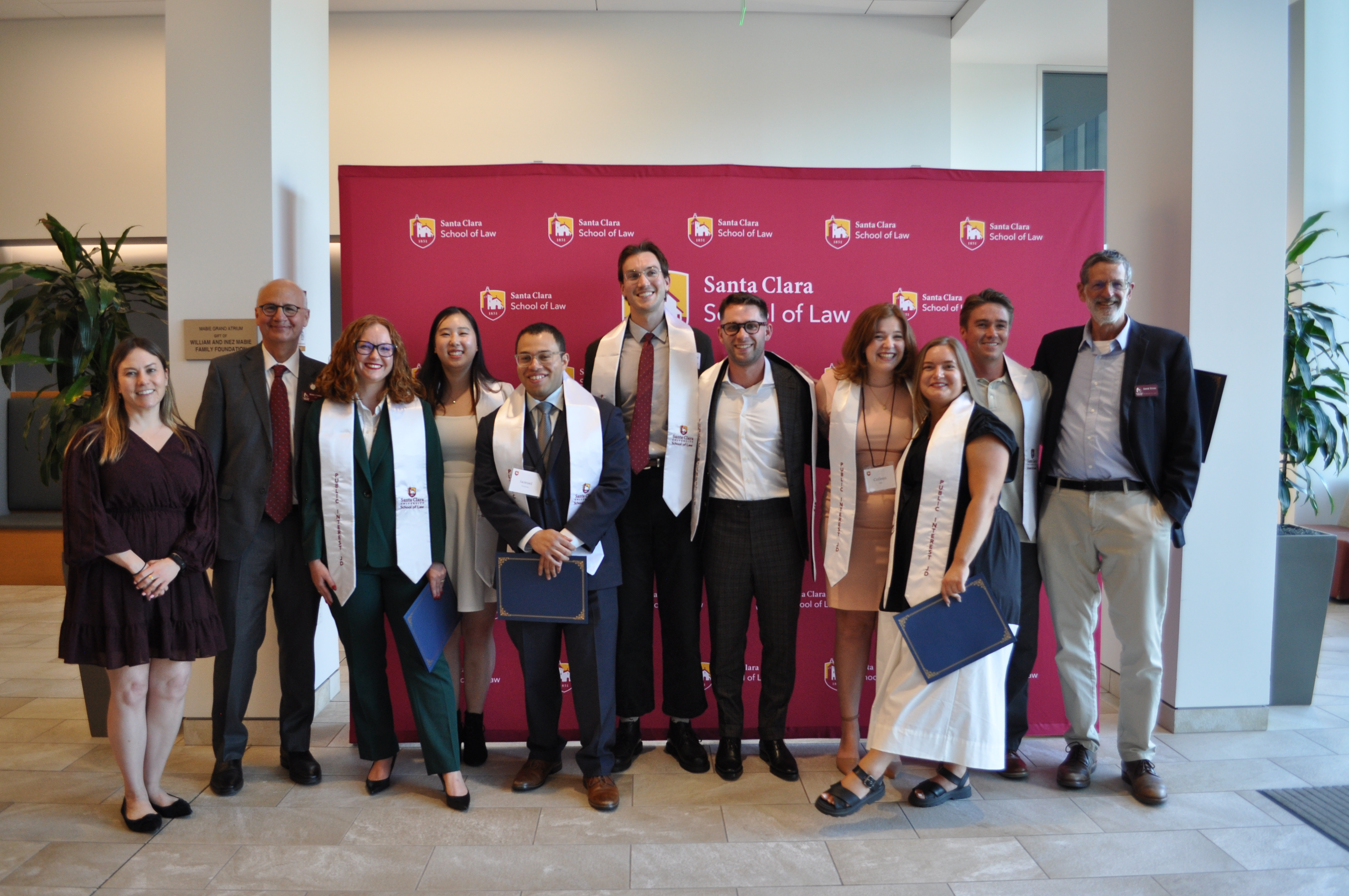students and faculty and Law School dean in inform graduation regalia