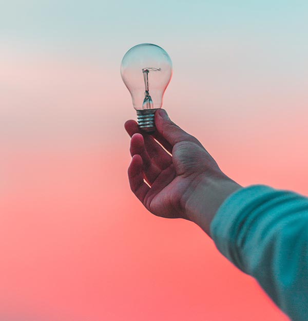 photo of person's hand holding up a lightbulb