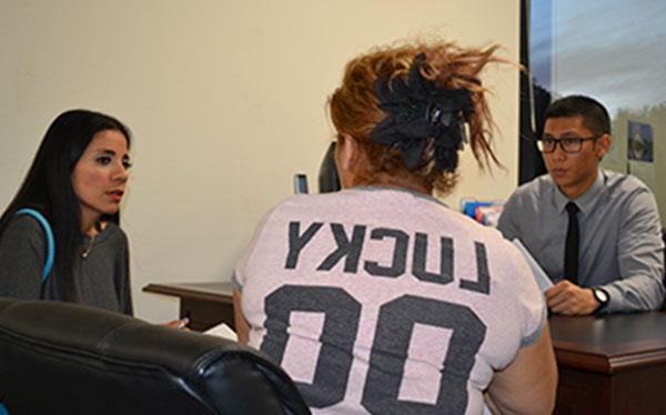 Second-year law student Brian Olfato interviews a client with the assistance of Spanish-speaking interpreter Esmeralda Huerta (left).